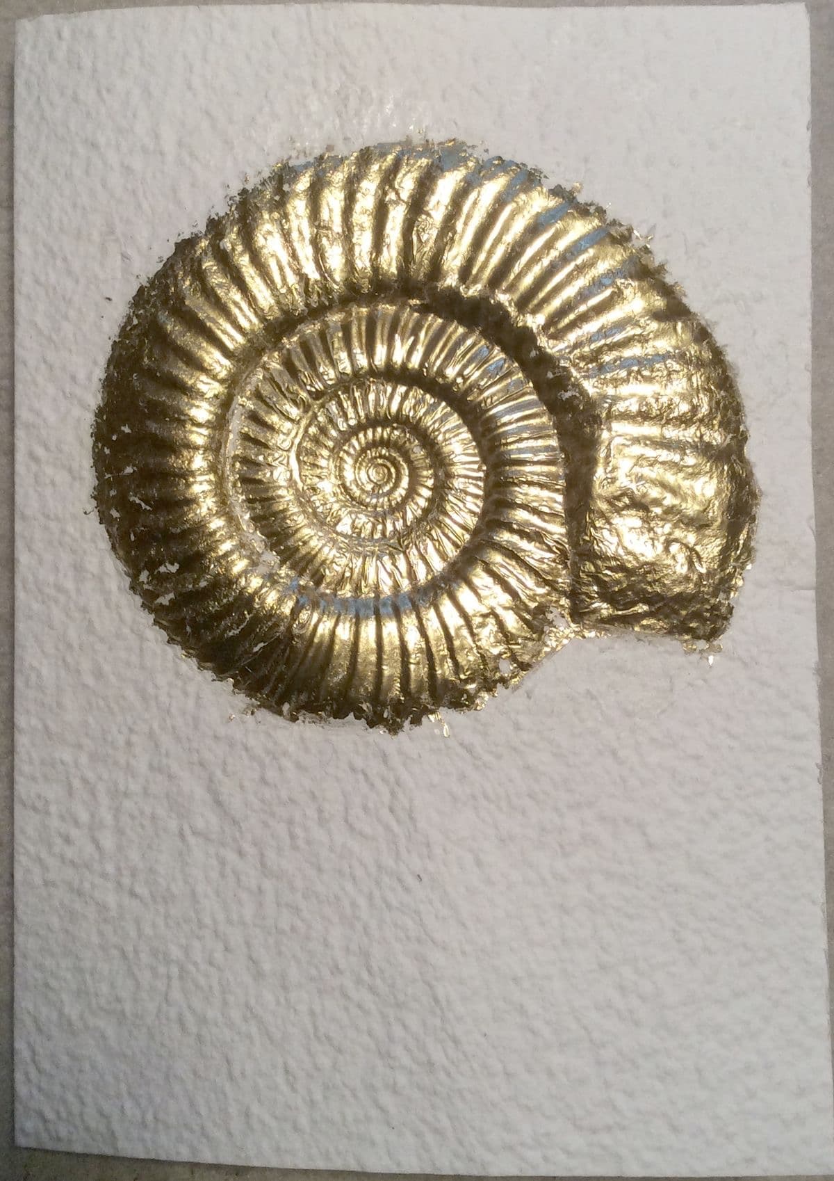 Gold spiral on textured paper